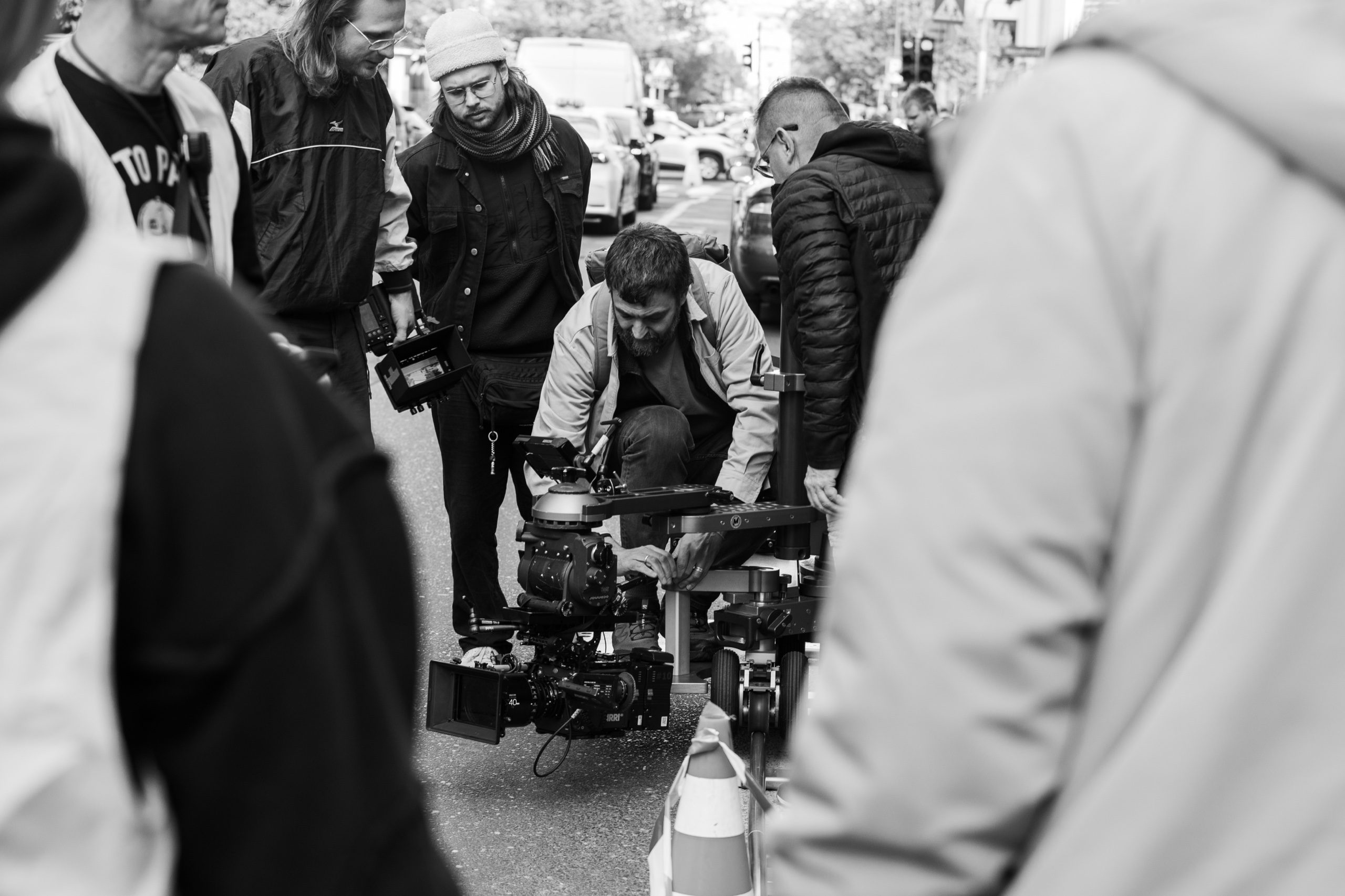 Camera crew adjusting a dolly rig on a street location