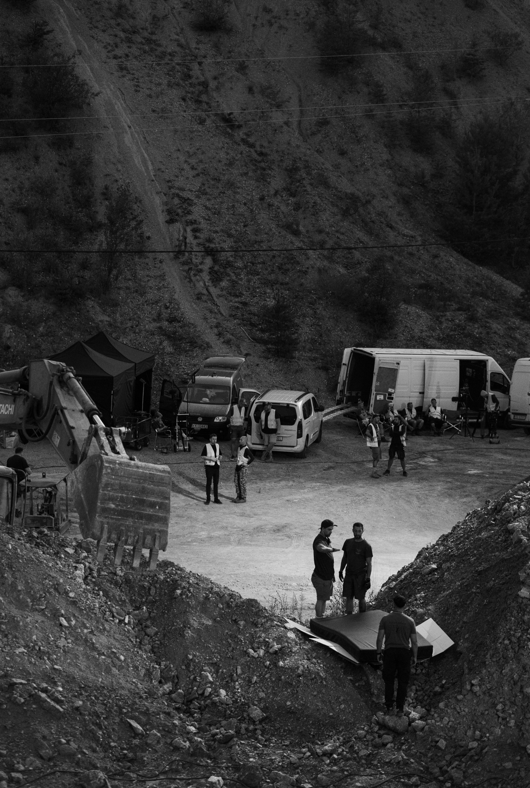 Film crew and production vehicles on a rocky exterior location